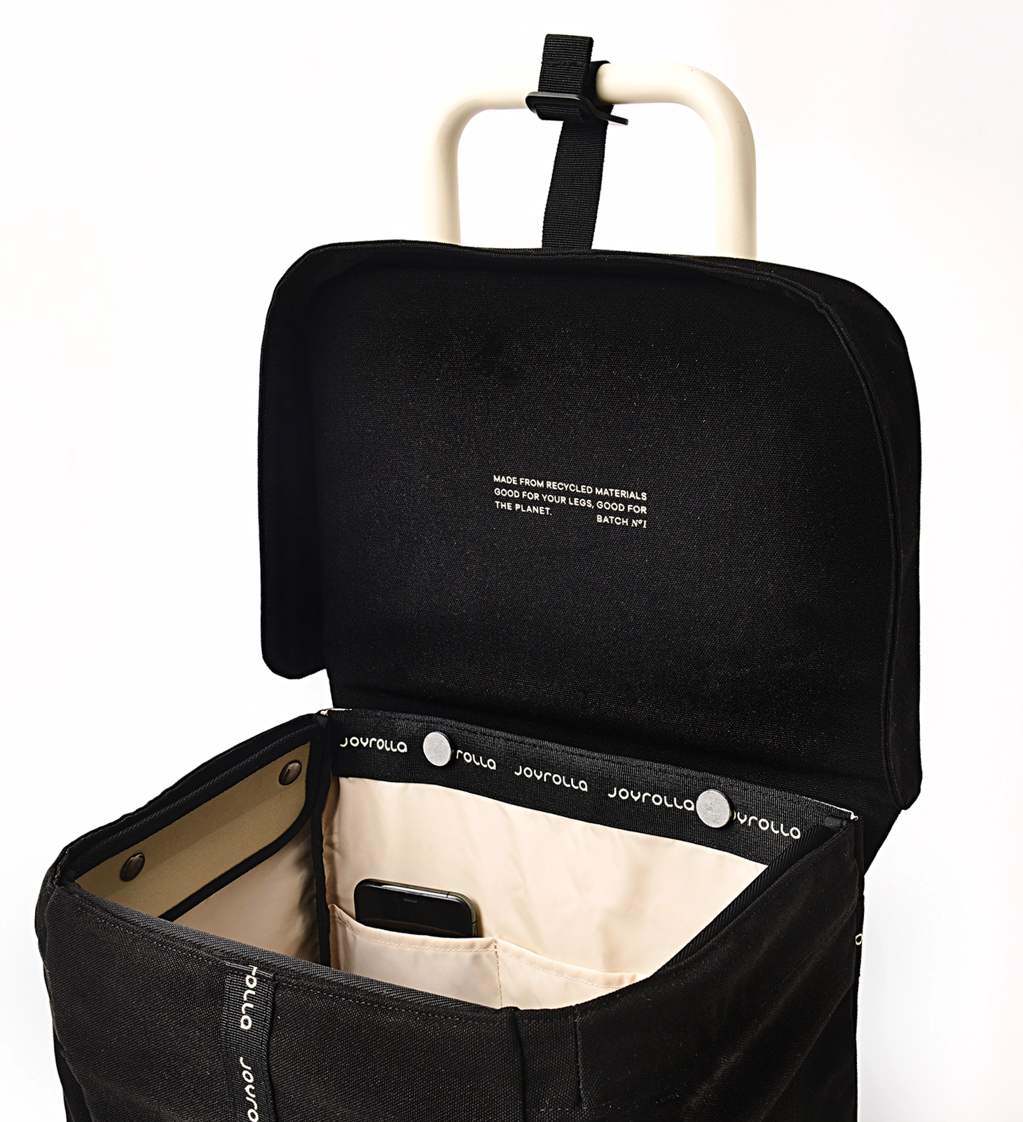 A detailed photo of the Joyrolla Cart with a black bag, showcasing its internal pockets and functional features. The cart's black bag is visible, featuring multiple internal pockets for organizing items. One pocket holds a phone securely. The lid of the cart is being held up by a handy strap, allowing easy access to the contents inside. This cart offers convenient storage solutions with its internal pockets, ensuring items are kept organized and easily accessible while on the move