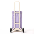 The back view of the Lilac Joyrolla Cart, emphasizing the logo detail on the bag and the strong, sturdy wheels. The wheels, visible from the back, are robust and built to handle various terrains, ensuring smooth and reliable transportation. This Lilac Joyrolla Cart combines style and durability, making it a practical choice for effortless rolling