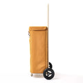 A side view of the Ochre Joyrolla granny cart, highlighting its tall handle and sleek design. The shopping cart features a long, ergonomic handle that reaches above waist height, allowing for comfortable maneuvering and effortless pushing or pulling. Its sleek design is characterized by clean lines and a streamlined silhouette. This Ochre cart combines functionality and style, offering a practical solution for transporting items with ease while exuding a modern aesthetic
